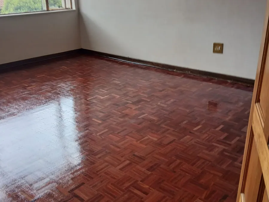 Deep red parquet floor sanded back and resealed in an empty room