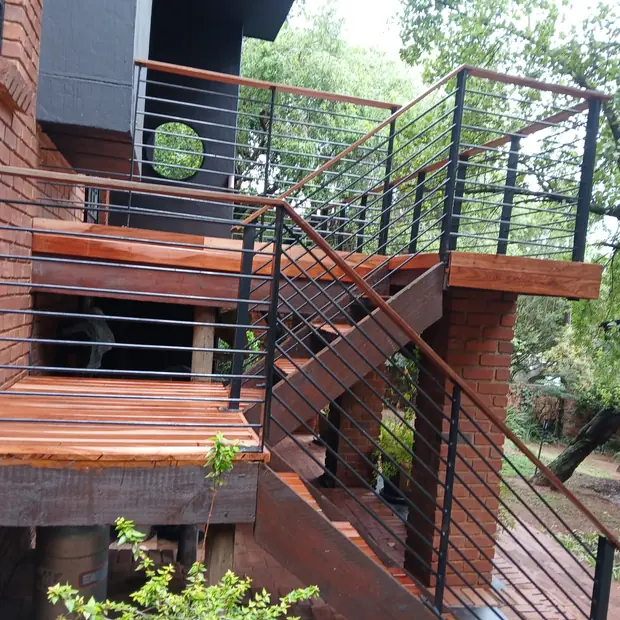Elevated hardwood deck with steel balustrade and timber stair in Johannesburg by Impi Teak
