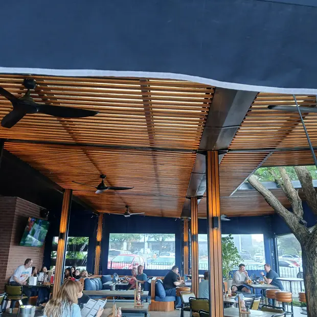 Timber slat ceiling and structure over a busy Johannesburg restaurant, built by Impi Teak