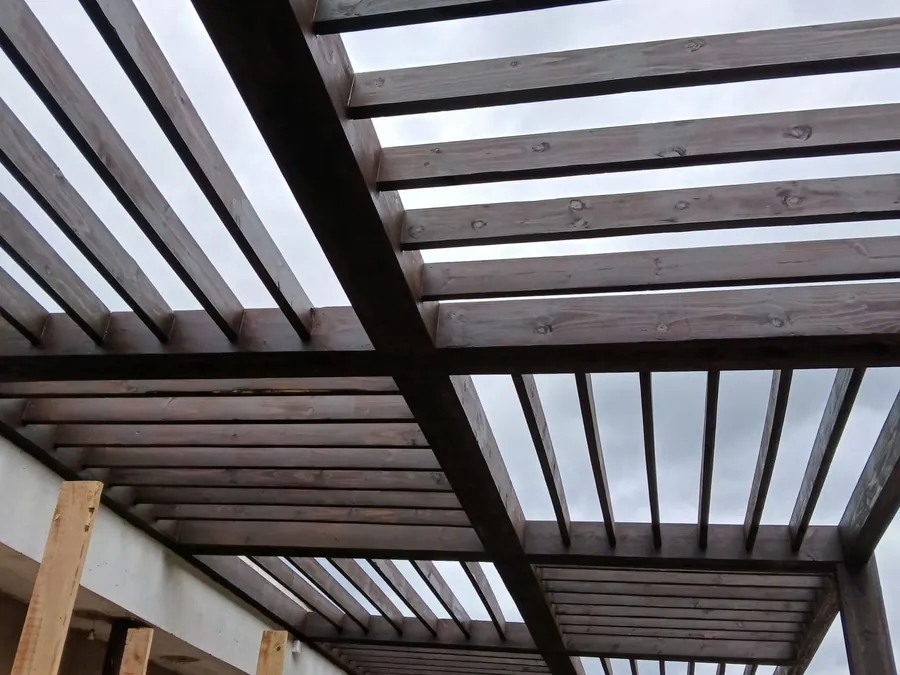 Underside of a timber slat roof structure showing beams and battens